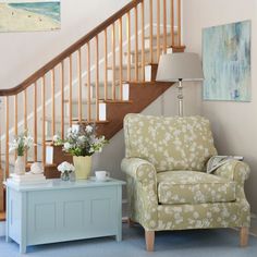 a living room filled with furniture next to a stair case and wooden bannister