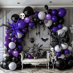 a room decorated for halloween with black, white and purple balloons in the shape of a wreath