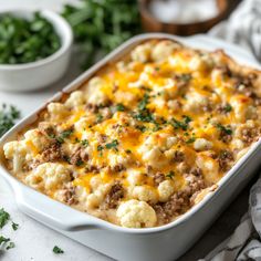 a casserole dish with meat, cheese and vegetables in it on a table