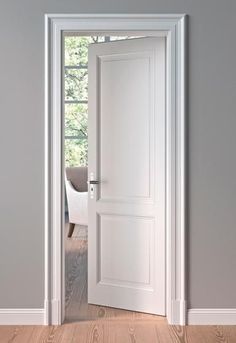 an open white door in a room with hardwood flooring and gray walls, leading to a dining area