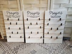 three white drawers with black pins on them and two are labeled prayer, prays