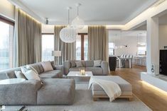 a living room filled with lots of furniture and a flat screen tv mounted on the wall