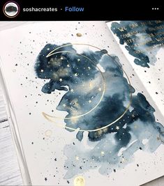 an open book with watercolors and gold foil on it, featuring the silhouette of a bear