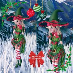 two elfs dressed in green and red with christmas decorations hanging from their heads, standing on snow - covered ground