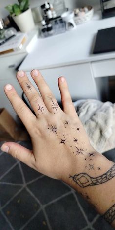 a person's hand with stars and chains tattooed on the middle of their palm