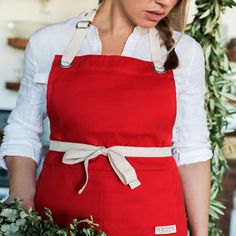 a woman in an apron holding a bunch of flowers