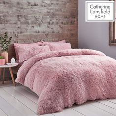 a bed with pink comforters and pillows