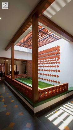 the inside of a house with an artificial lawn and pergolated roof over it