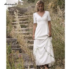 a woman in a white dress is standing on some steps and looking at the camera