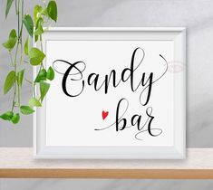 a white framed sign that says candy bar with a red heart in the center and some green leaves around it