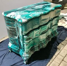 a large green painted chest sitting on top of a blue tarp