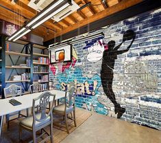 a mural on the side of a brick wall in an office with chairs and tables