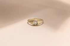 a yellow gold ring with a single diamond