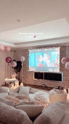 a living room filled with lots of furniture and balloons in front of a flat screen tv