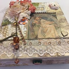 an old box with lace, beads and flowers on it