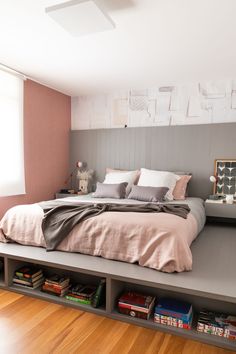 a bedroom with pink walls and grey bedding