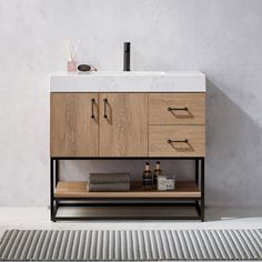 a bathroom vanity with two drawers and a sink in front of a wall mounted faucet