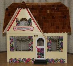 a doll house made out of cardboard and decorated with flowers