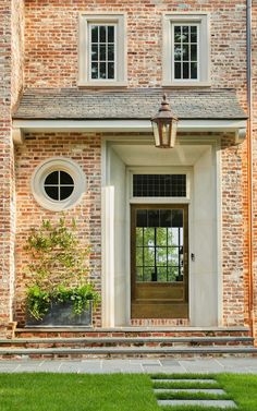 a brick house with an entry way and steps leading up to the front door area