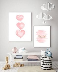 two pink hearts are hanging on the wall above a white table and chair in front of it