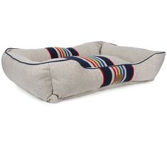 a dog bed with stripes on the front and back, made from grey linens