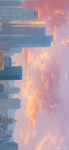 the sky and clouds are reflected in the water below skyscrapers on a cloudy day