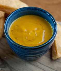 a blue bowl filled with soup next to some fried food