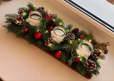 a candle holder decorated with pine cones and candles