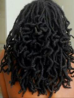 the back of a woman's head with long black dreadlocks on it