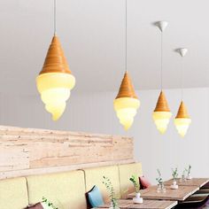 a restaurant with wooden tables and chairs, hanging lights above the booth area for seating