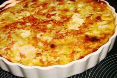 a casserole dish sitting on top of a stove in a white pan with cheese