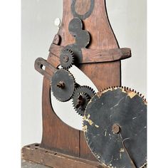 an old wooden clock with gears attached to it