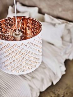 a white and brown lamp hanging from a ceiling