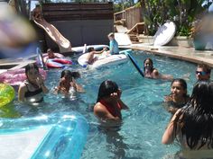 several people are in the pool playing with water toys