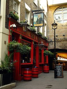 a red building with potted plants on the outside