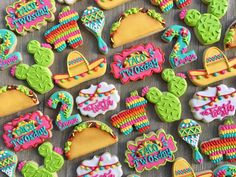 some decorated cookies are sitting on a table with the words happy hooray written in bright colors