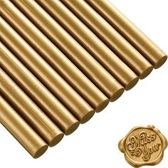 gold colored metal rods are lined up on a white background