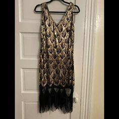 Black With Gold Sequins, Fully Lined. Double V-Neck. Brand New, Never Worn, Tags Removed. Vintage Black Flapper Dress With Beaded Fringe, Glamorous Black Flapper Dress With Fringe, Black Gatsby Style Dresses With Fringe, Black Gatsby Style Fringe Dresses, Black Fringe Gatsby Dresses, Black Flapper Dress With Fringe, Elegant Fringed Flapper Dress For Costume Party, Elegant Fringe Flapper Dress For Costume Party, Vintage Black Flapper Dress For Party Season