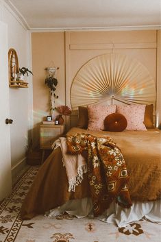 a bedroom with a large bed covered in blankets and throw pillows on the floor next to it