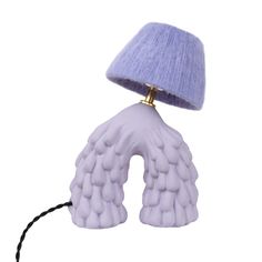 a purple lamp that is on top of a white surface with a black cord attached to it