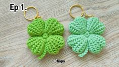 two crocheted shamrock keychains sitting on top of a wooden table