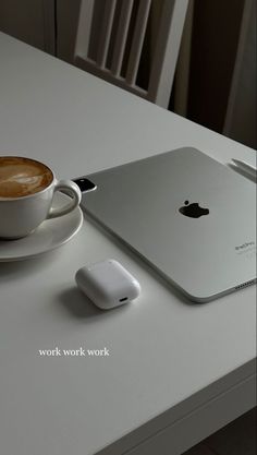 an apple laptop computer sitting on top of a table next to a cup of coffee