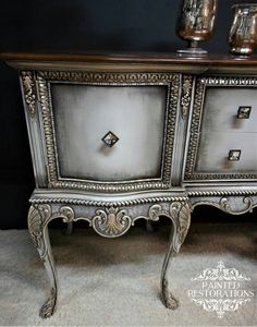 an ornately decorated silver dresser with two drawers and three glass vases on top