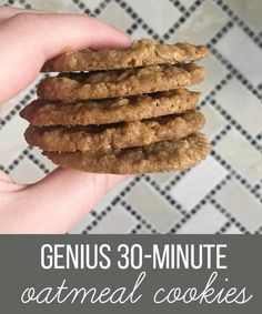 a hand holding a stack of oatmeal cookies with the words genius 30 - minute oatmeal cookies