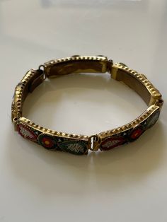 A vintage micro mosaic base metal bracelet, circa 1930-40. Vintage Brass Bracelet With Intricate Design, Vintage Adjustable Bracelets With Intricate Design, Retro Multicolor Bracelet Jewelry, Vintage Multicolor Bracelets For Festive Occasions, Formal Bangle Bracelets With Inlay, Formal Bangle Bracelet With Inlay, Vintage Gold Enamel Bracelets, Vintage Brass Bangle Bracelets, Vintage Metal Bangle Bracelets