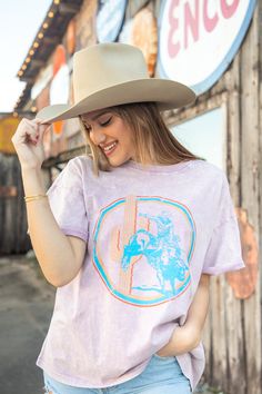 This lilac t-shirt is the perfect shirt for your next rodeo, outing, or even movie night! The shirt features a cowboy riding a bull with a cactus in the background surrounded by a tri-color circle. Bull Riding, Color Circle, The Shirt, Tri Color