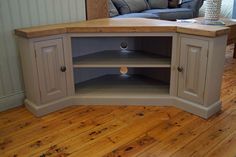 a corner tv stand in the middle of a living room