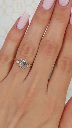 a woman's hand with pink manicured nails and a ring on her finger