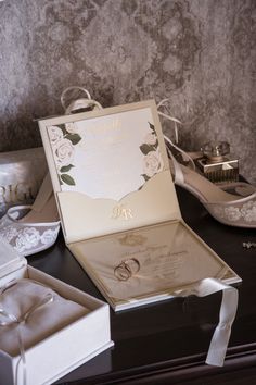 a wedding card and ring box on a table next to some other items that include shoes