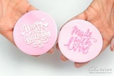 two handmade birthday cookies in pink and white frosting with happy birthday written on them